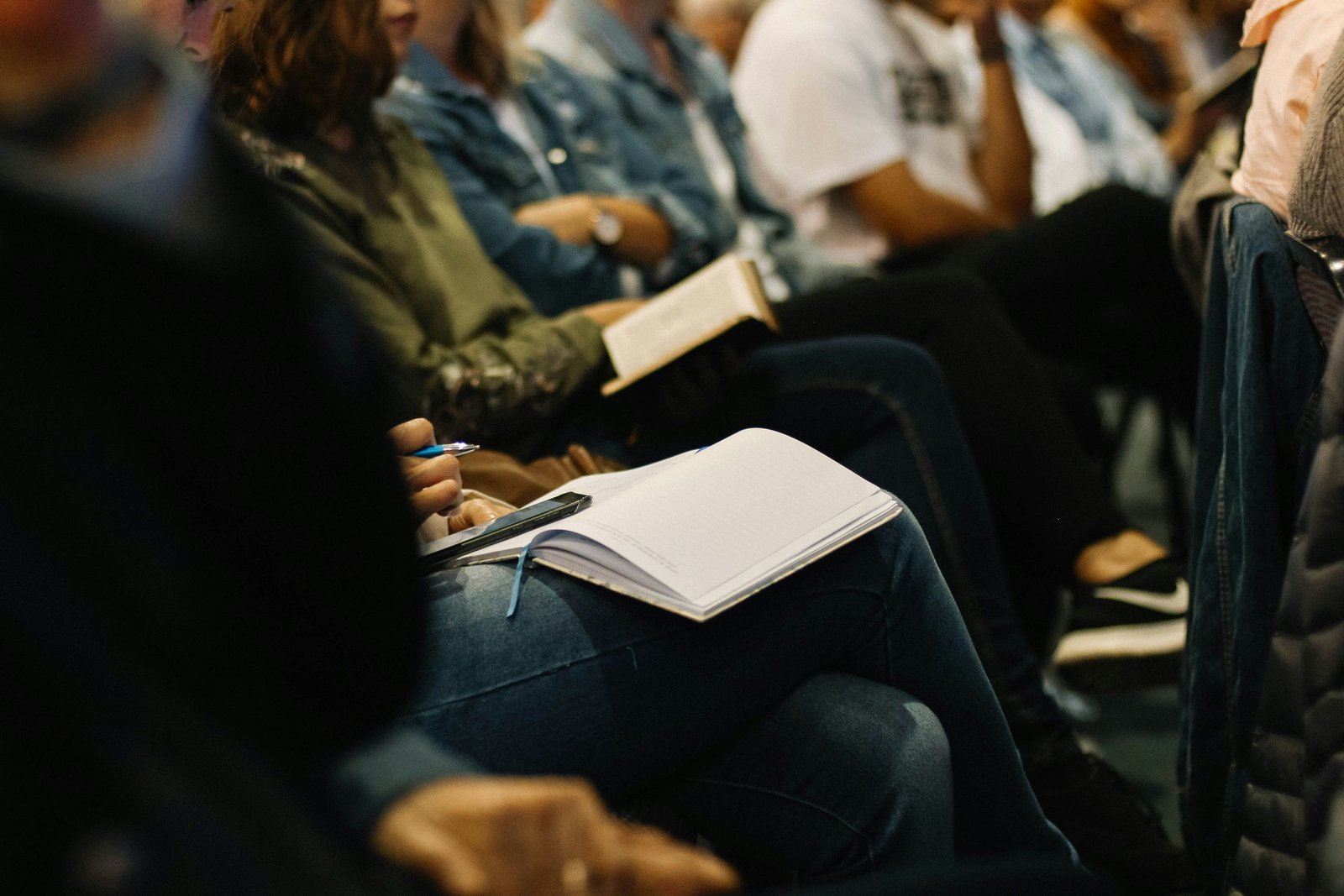 Close view of attendees seated in rows, taking notes during a session